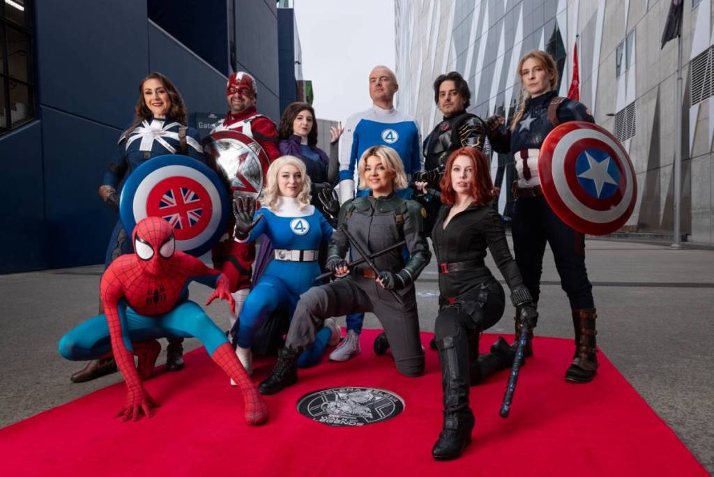 Marvel characters like Spider-Man posing in front of a plaque on the Walk of Legends at Marvel Stadium