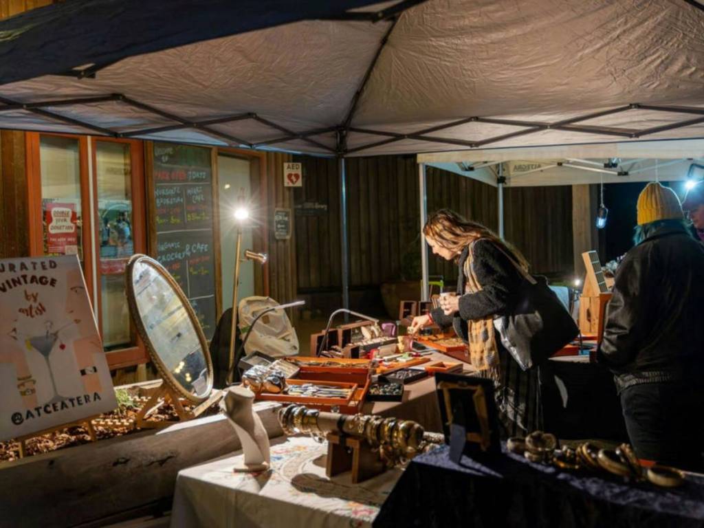 woman looking at items from a stall at the CERES Winter Twilight Market