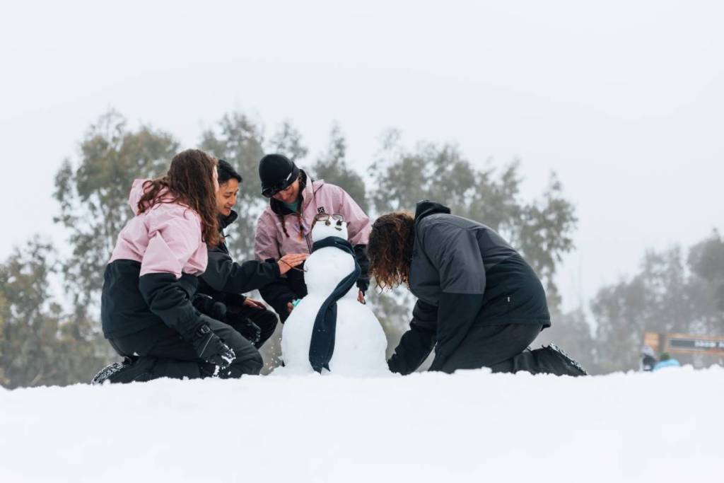 family making a snowman on Lake Mountain