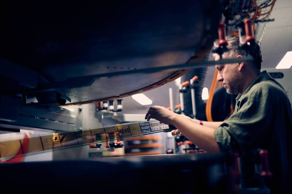 man loading The Odyssey film into projector at IMAX Melbourne