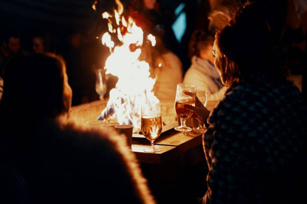 people enjoying drinks around a fire