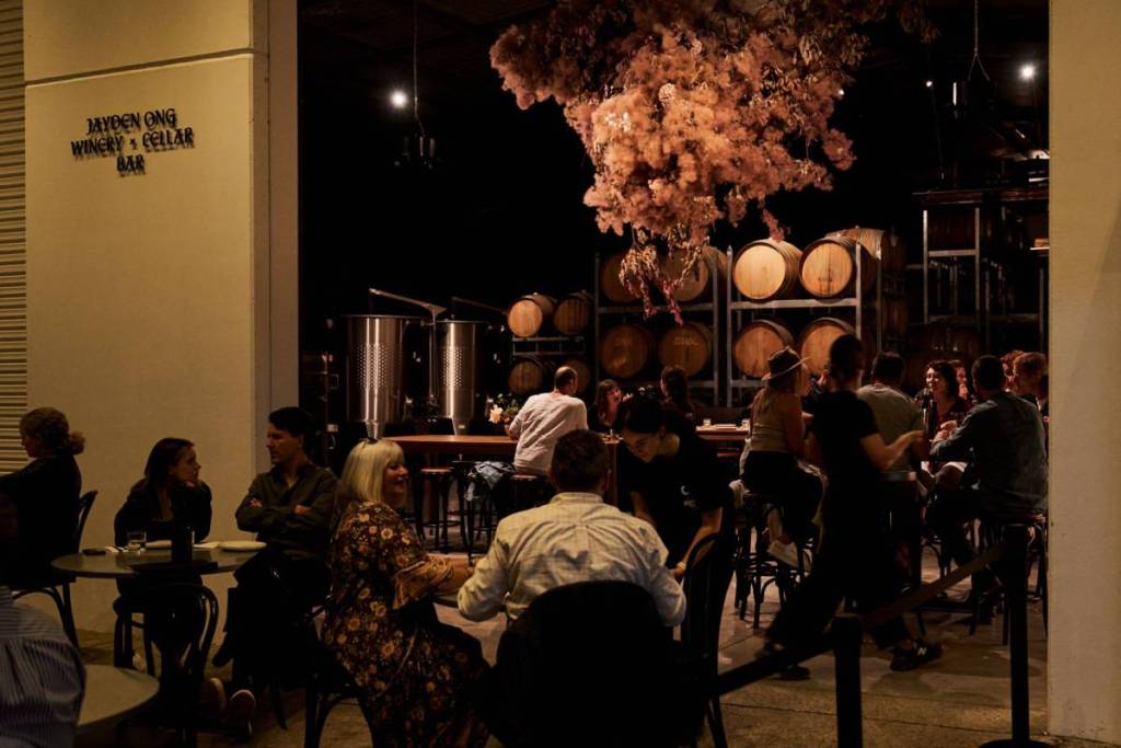 people around tables having drinks in the low-lit space at Jayden Ong Winery and Cellar Bar