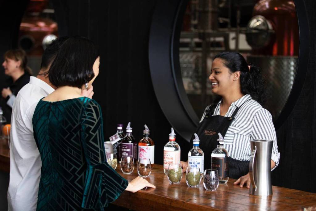 people chatting to a bartender at Four Pillars Gin