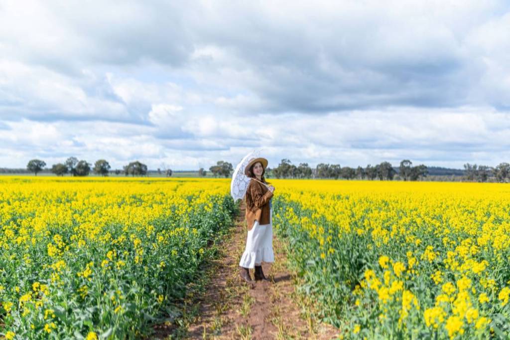 woman with parasol posing on the track at the Cornella Canola Walk