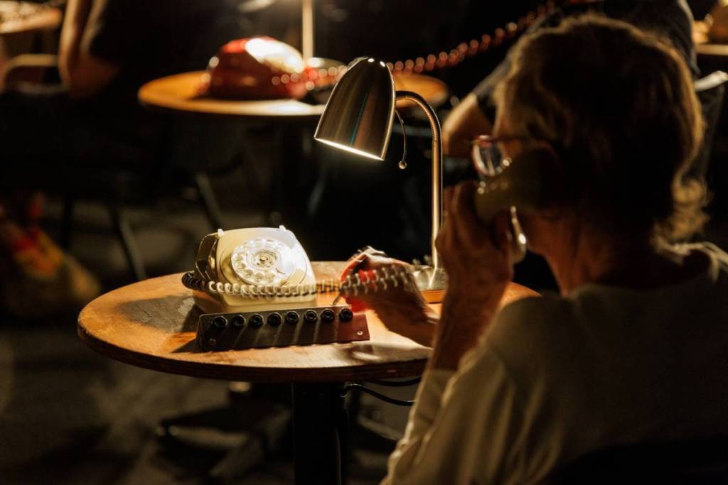 someone listening to a message on a vintage phone at The Nightline