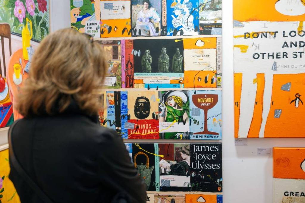 woman looking at book cover art at Affordable art fair melbourne