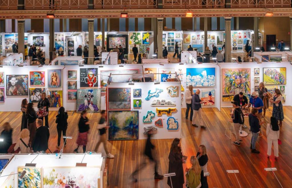 people walking through royal exhibition hall for artwork viewing and purchasing