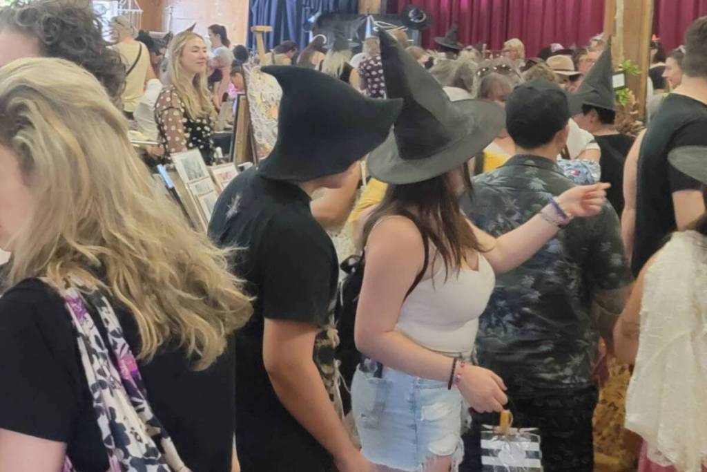 people gathered at a witches market, dressed in witches hat
