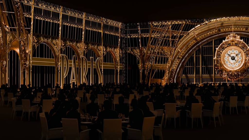people dining for Chateau Merveilles, with projections on the walls looking like Orsay Station