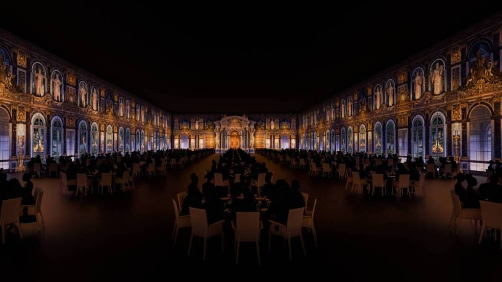 people dining at Chateau Merveilles, with the Mirror Room projected on the walls