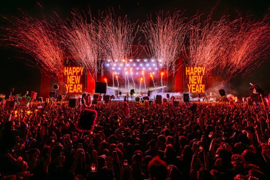 streamers and signs saying happy new year on stage in front of massive crowd at Beyond The Valley