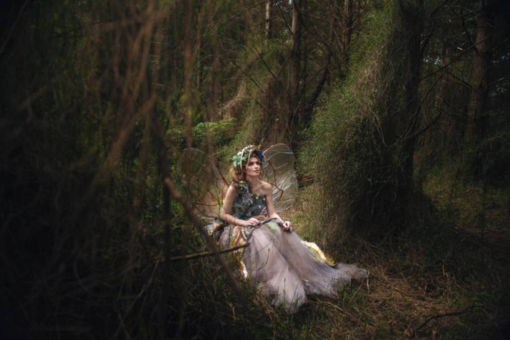fairy woman walking through a dark forest
