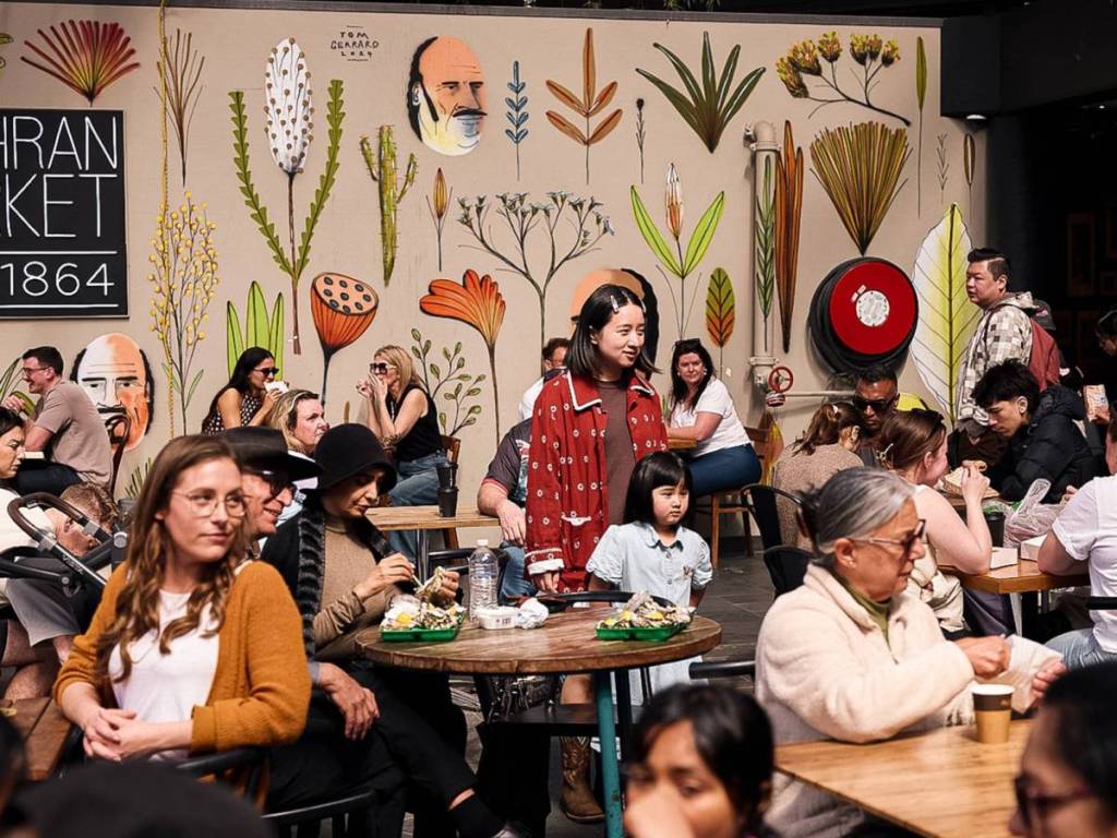 people sitting at tables and eating in Prahran Market