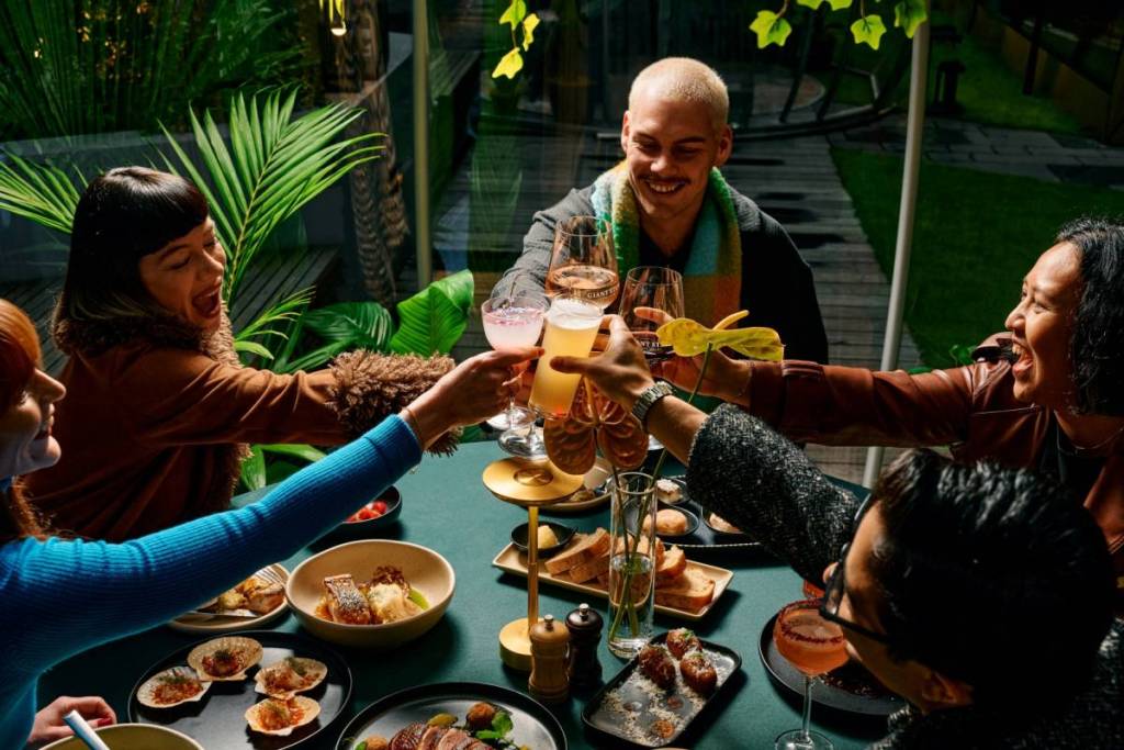 people doing cheers over their dinner at Fern's Hidden Winter Garden