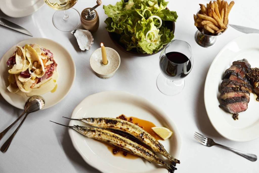seafood, steak and other dishes on a table at Cote Basque