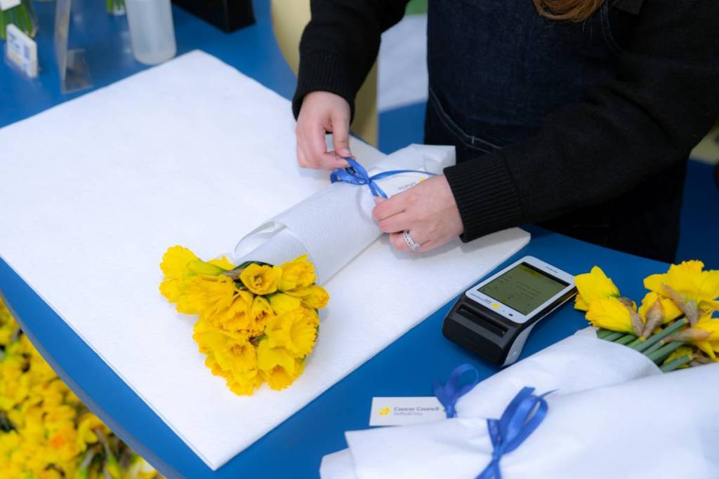 someone wrapping up a bunch of daffodils