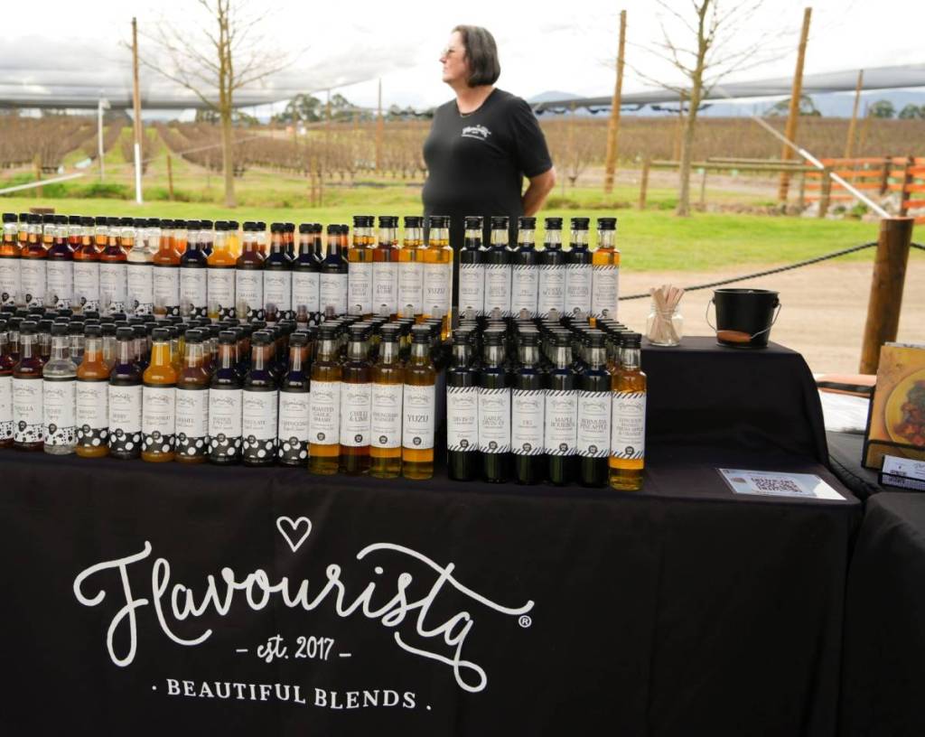 woman behind stall selling sauce blends at Bloom & Graze in CherryHill Orchards