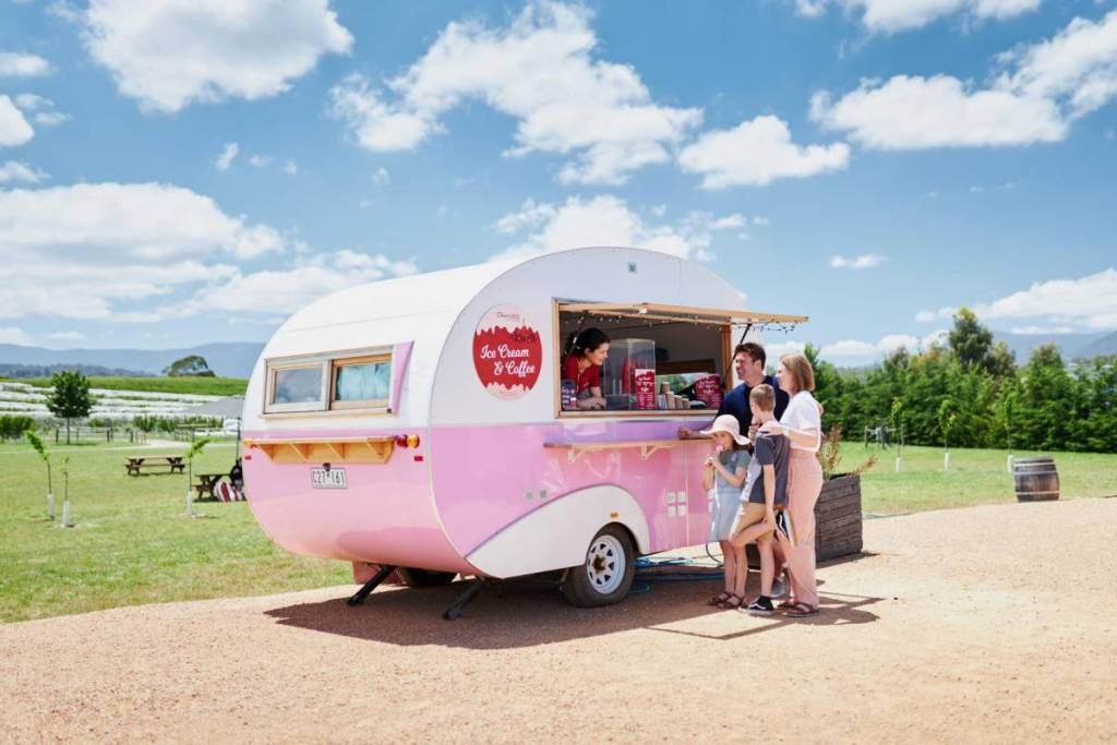 a family getting ice cream from a pink caravan at CherryHill Orchards
