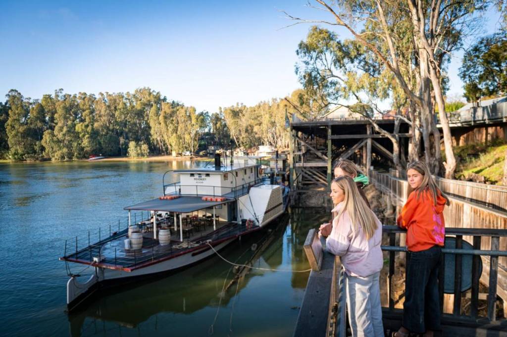 three women hanging out at the Port of Echuca with a paddlesteamer in the background