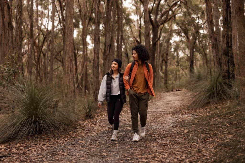 two people walking along a forest trail in Woowookarung Regional Park