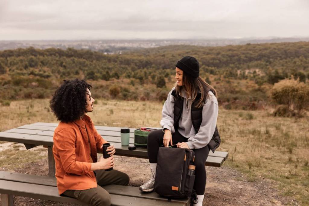 two people on a picnic table at a lookout in Woowookarung Regional Park