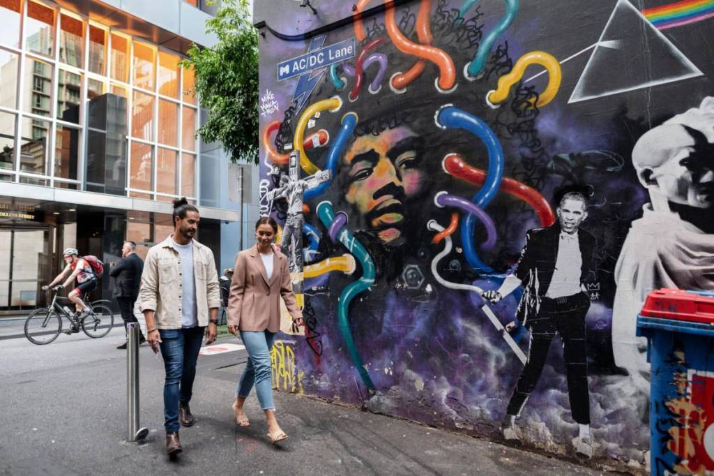 two people walking into AC/DC Lane to look at street art