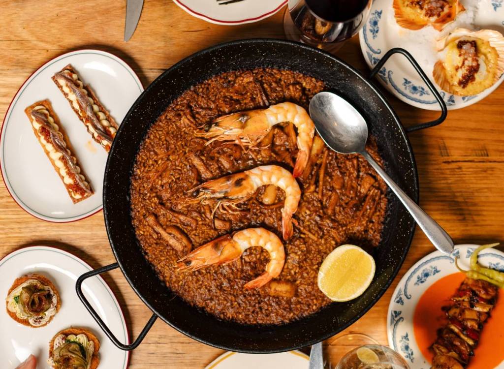 a paella with 3 prawns on top