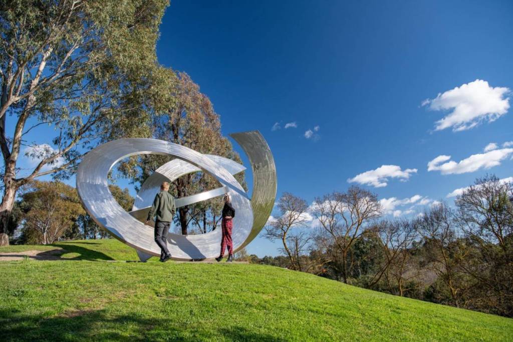 two people looking at a sculpture in the park at Heide Museum of Modern Art