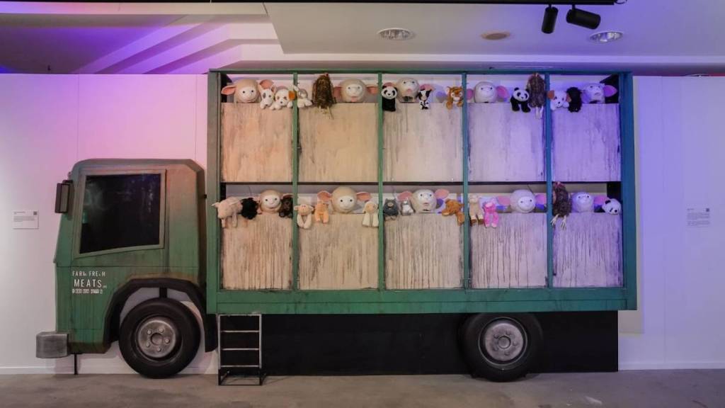 A cut out of a large truck filled with stuffed animals at Banksy Limitless.