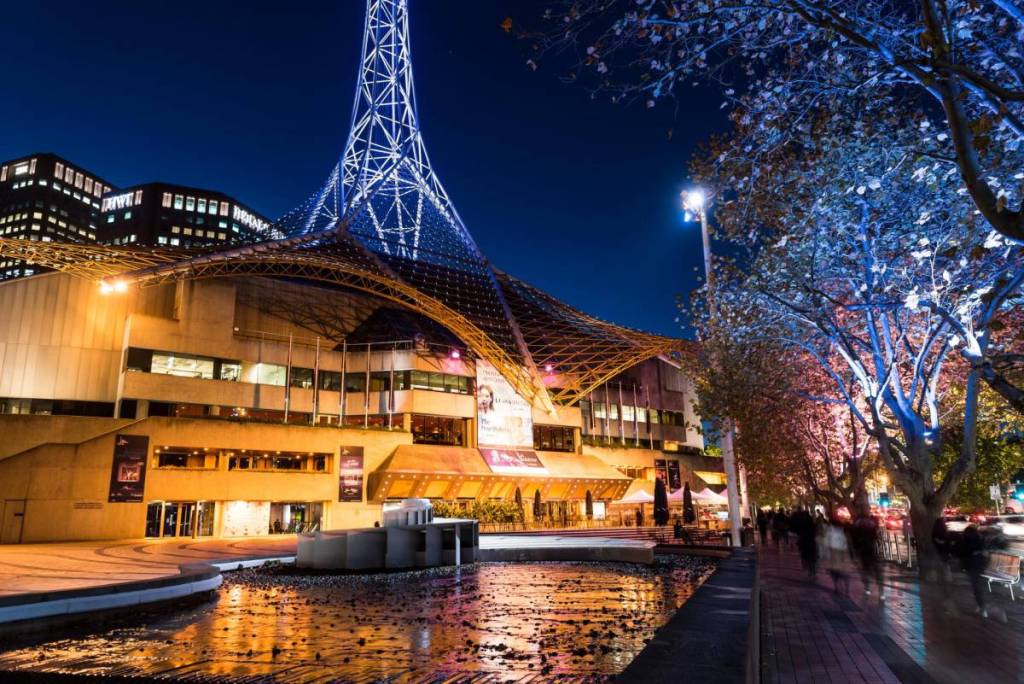 outside Arts Centre Melbourne theatre building at night, with the bottom of the spire in view