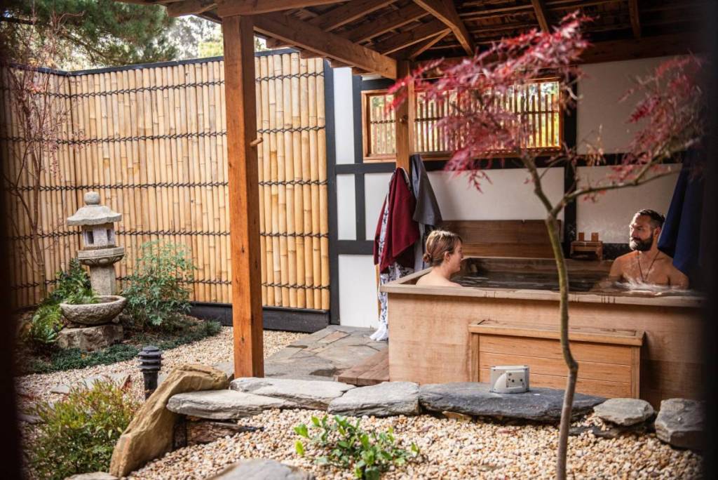 two people in a bath in a private courtyard at Shizuka Ryokan