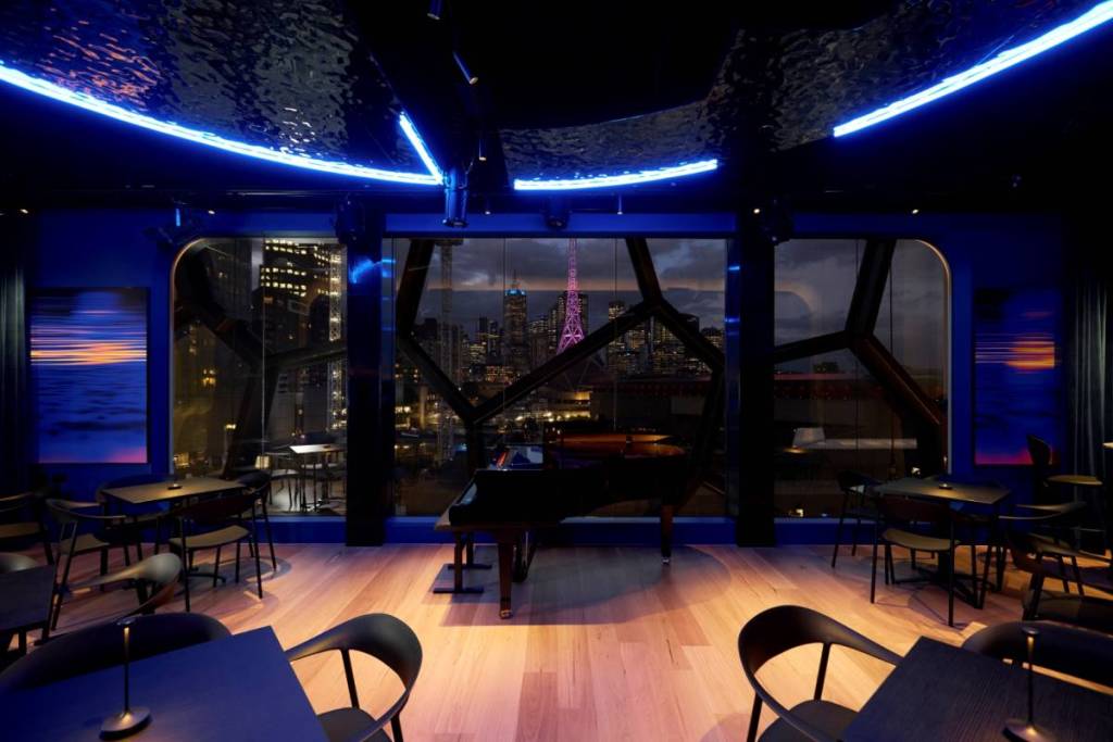 inside the Beacon at Melbourne Recital Centre, looking out beyond a piano to skyline views