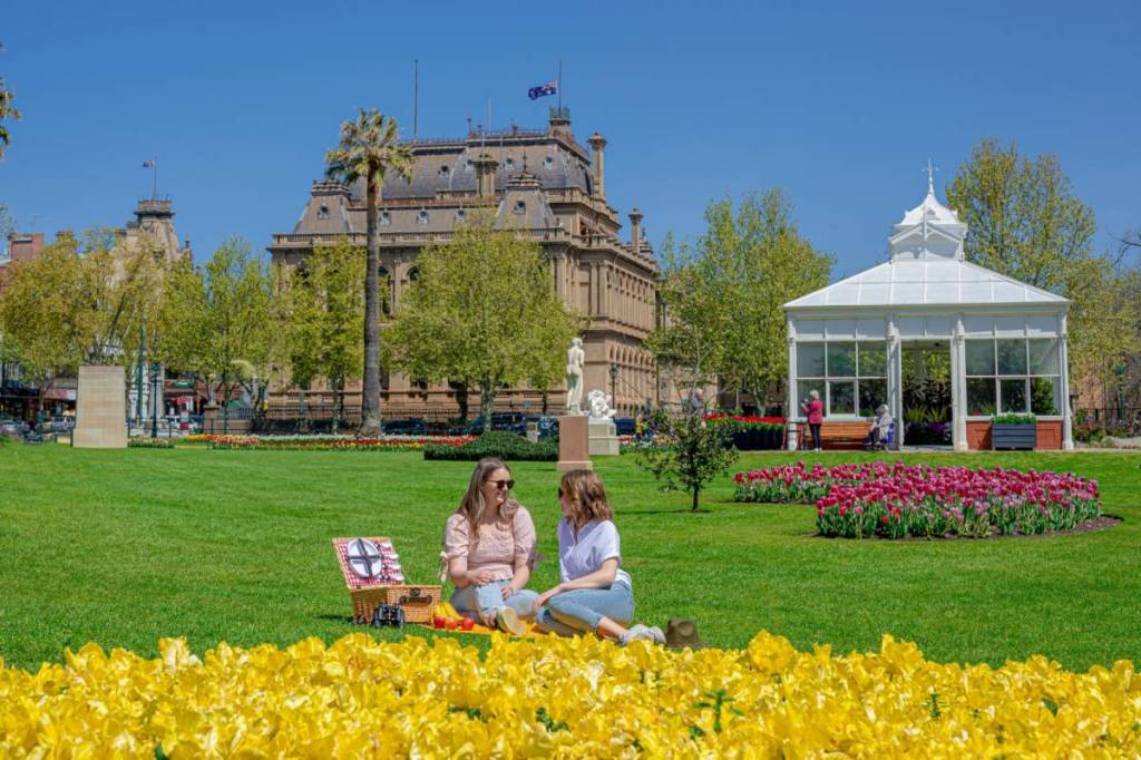 two people having a picnic among spring flowers in a park in Bendigo
