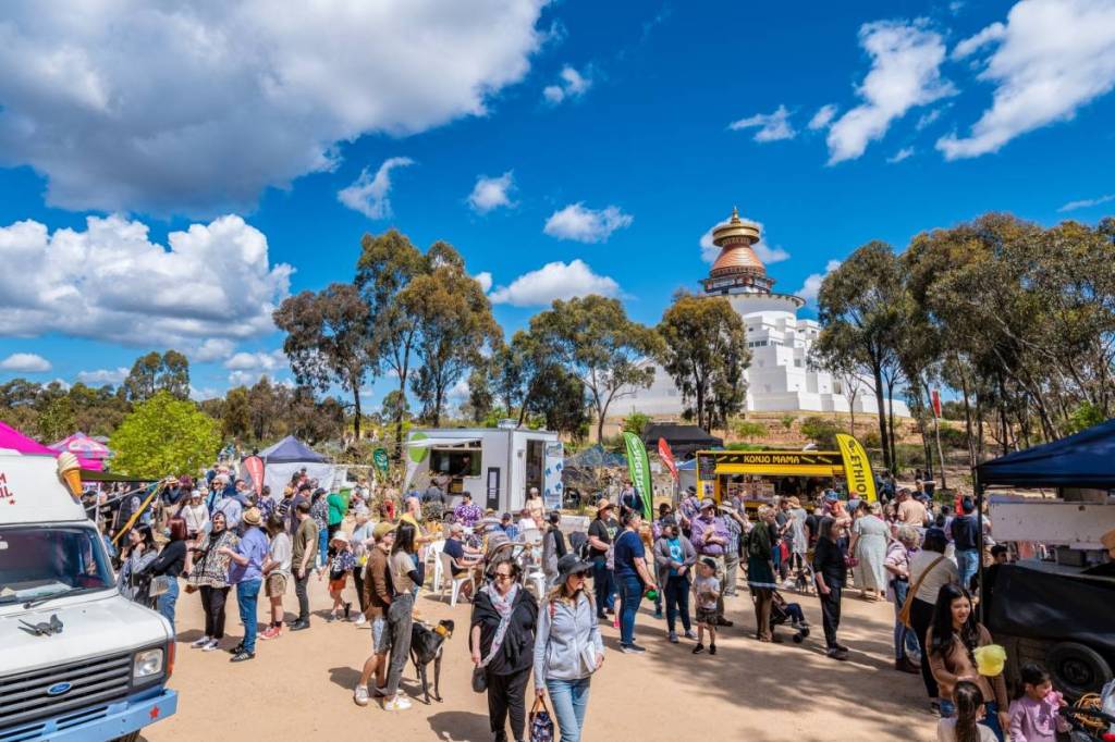 people browsing among food trucks at a festival at the Great Stupa of Universal Compassion in Bendigo