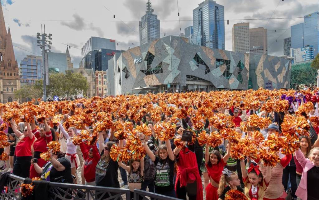 people with pom poms taking part in the Melbourne Cheer Challenge at Fed Square