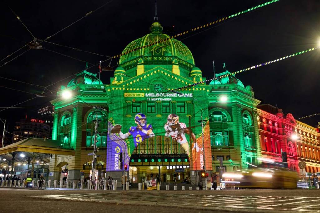 Flinders Street Station lit up with projections promoting the NFL in Melbourne