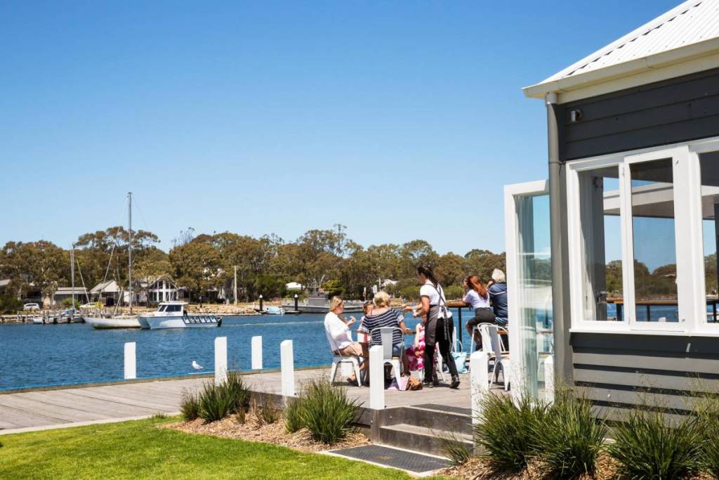 people dining outside by the water at Pier 70 in Paynesville