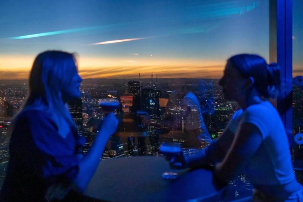two women having a drink and taking in the view from Melbourne Skydeck at sunset