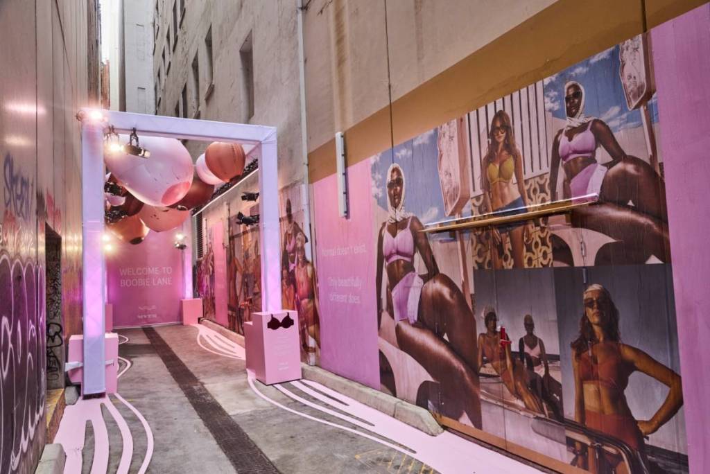 a view of Boobie Lane, with advertising for Nala bras on the walls, and the inflatable breast sculptures further back