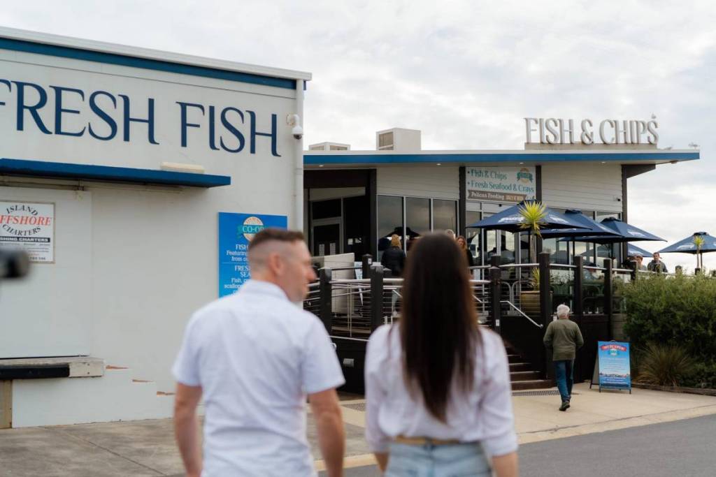 two people walking towards fish and chips shop in San Remo