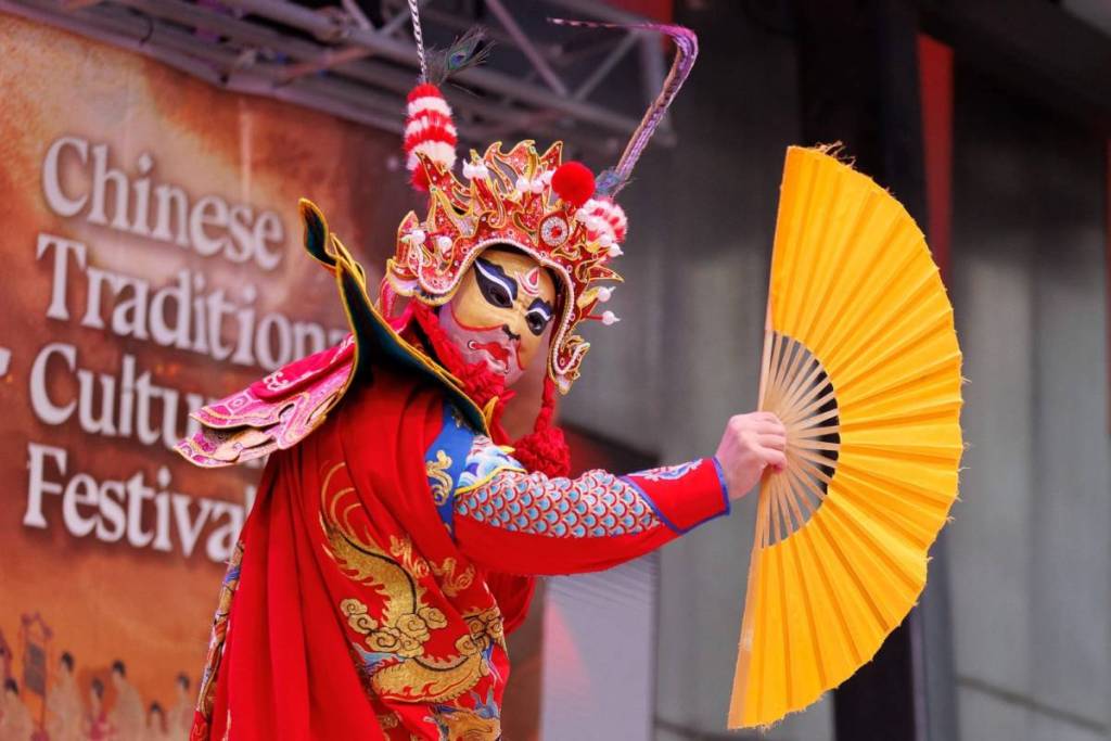 masked performer holding a fan at Chinese Traditional Cultural Festival