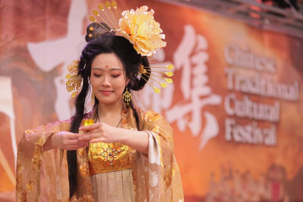 woman in gold traditional costume on stage at Chinese Traditional Cultural Festival