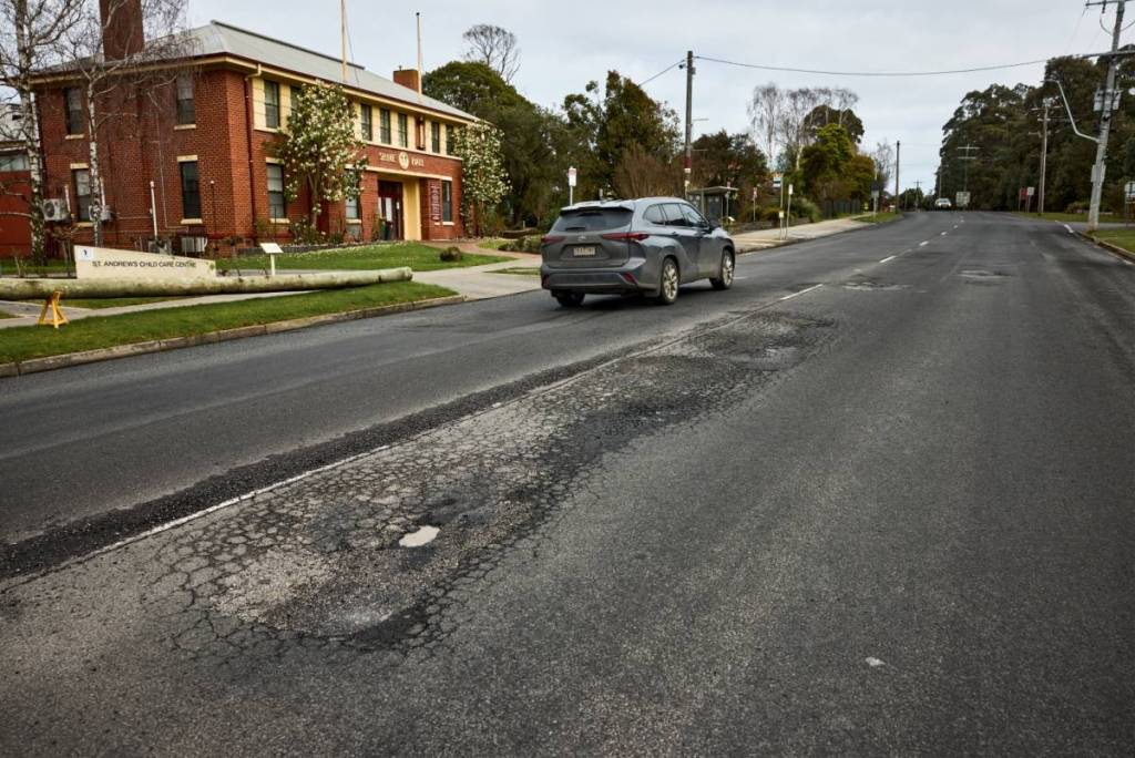 car driving along Strzelecki Highway with road damage visible