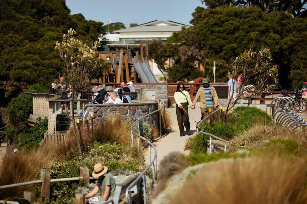 people enjoying the Point Lonsdale foreshore, with a playground visible in the background, and lots of paths