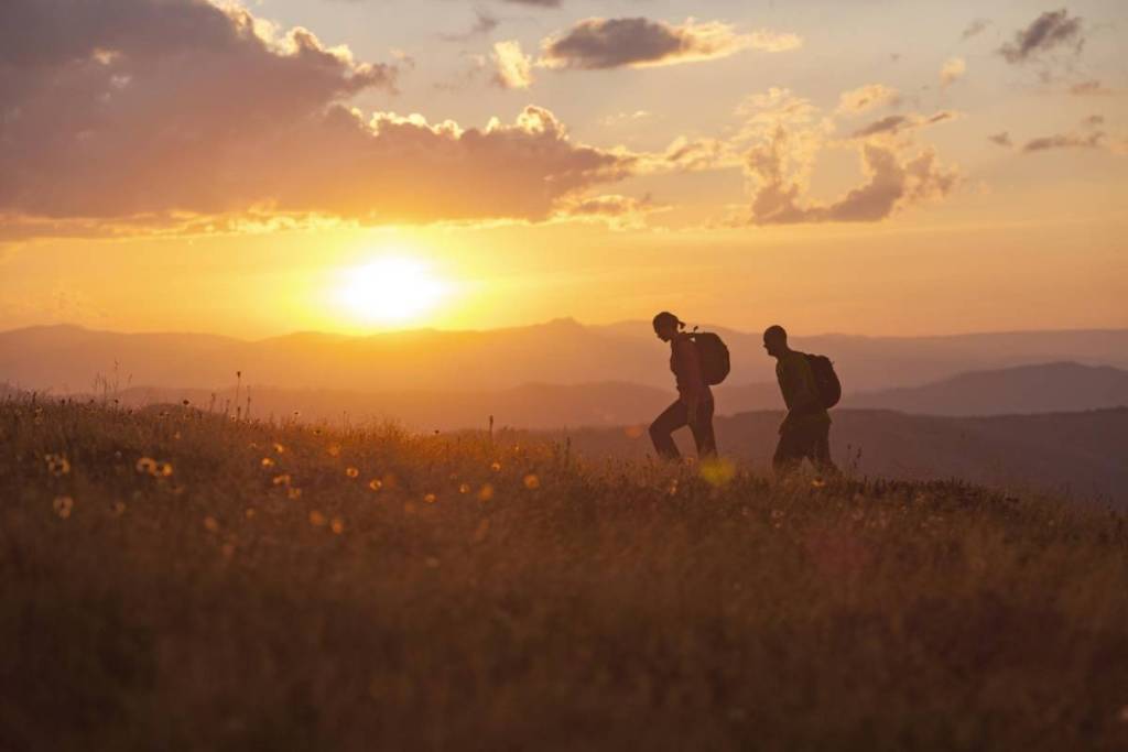 sunset on Razorback trail to Mt Feathertop, with two hikers wearing backpacks in silhouette