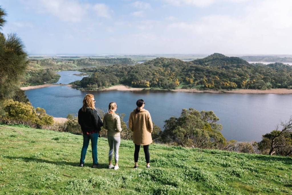 three people looking at the lakes and trees below in Tower Hill Wildlife Reserve