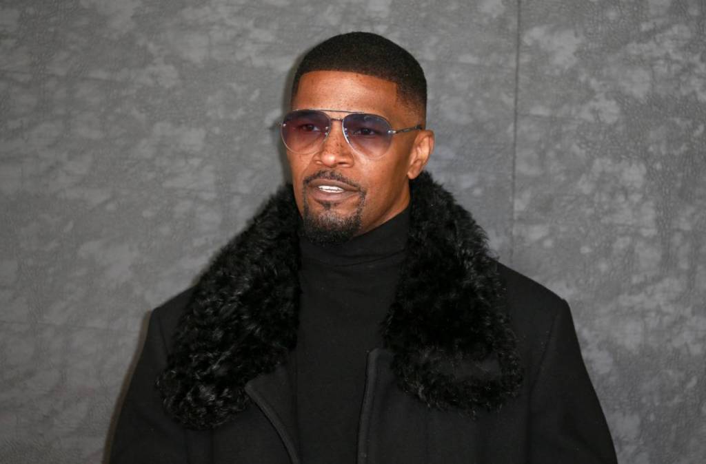 Jamie Foxx dressed in black and wearing sunglasses at a red carpet event