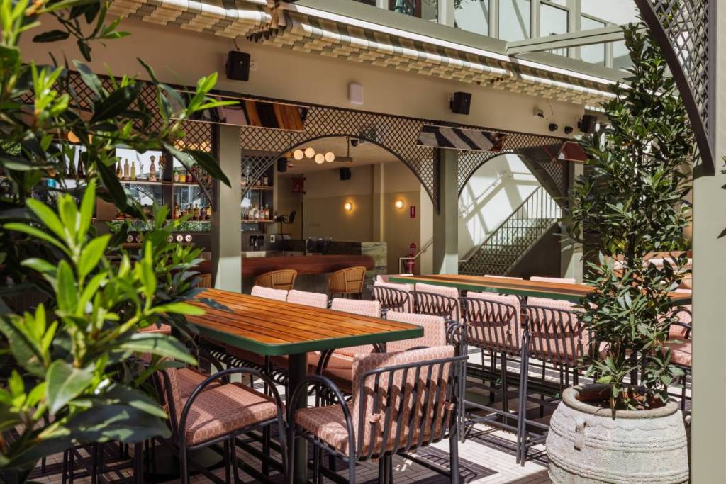tables and chairs with greenery at Garden State Hotel rooftop