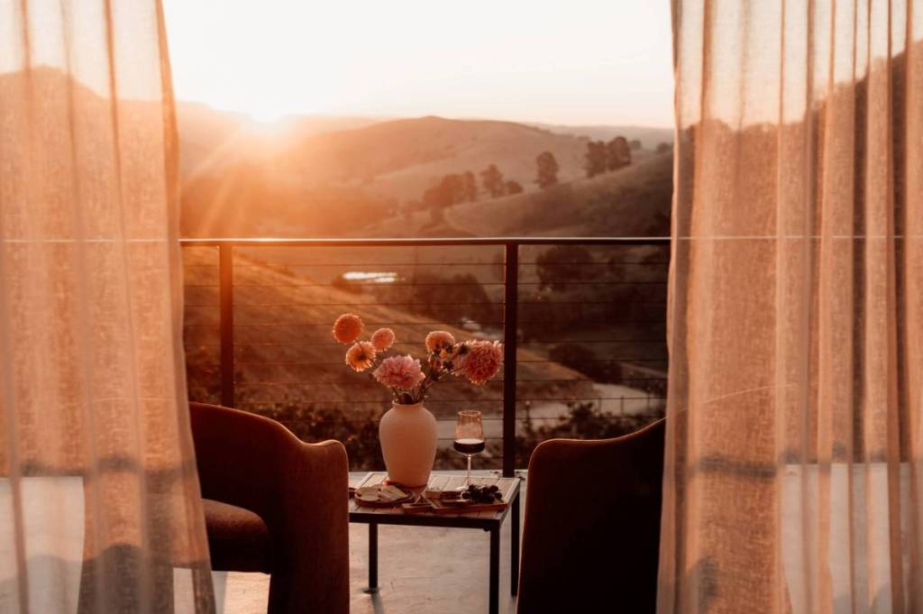 bouquet of flowers on a coffee table at a balcony overlooking hills at Bloom Into You Flower Farm