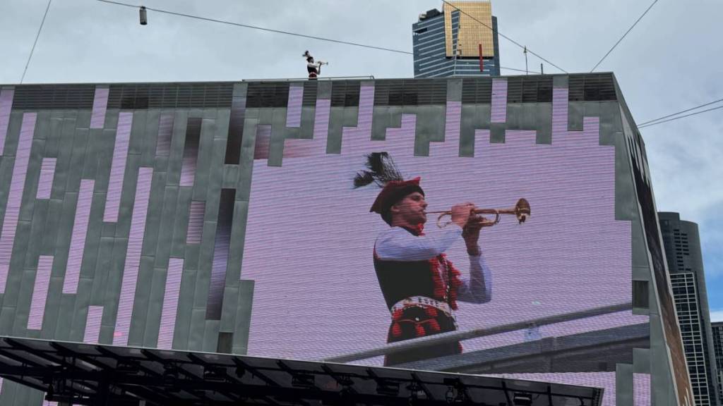 trumpeter playing in Fed Square, seen on the big screen over the Main Stage
